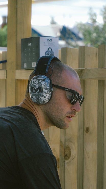 Tradie wearing Mufftech Sole Bluetooth earmuffs and sunglasses outdoors with retail packaging