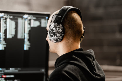 Technician working in a server room wearing Mufftech Sole Bluetooth earmuffs